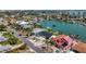 Aerial view of waterfront homes showcasing their proximity to the water, lush landscaping and a neighborhood bridge at 240 N Julia Cir, St Pete Beach, FL 33706