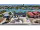 Aerial view showcasing the waterfront home's proximity to the water, with lush landscaping and a private driveway at 240 N Julia Cir, St Pete Beach, FL 33706