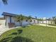 Beautifully landscaped backyard with lush lawn and outdoor seating area at 240 N Julia Cir, St Pete Beach, FL 33706