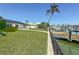 Waterfront home featuring a green lawn and dock at 240 N Julia Cir, St Pete Beach, FL 33706