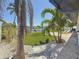 Waterfront home featuring tropical landscaping including palm trees and white rock at 240 N Julia Cir, St Pete Beach, FL 33706