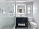 Well-lit bathroom with glass shower, vanity with storage, and subway tile at 240 N Julia Cir, St Pete Beach, FL 33706