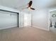 Bedroom showcasing neutral tones, ceiling fan, carpet, walk-in closet, and ensuite bathroom at 240 N Julia Cir, St Pete Beach, FL 33706