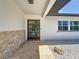 Close-up showcasing the home's entrance with a modern door, stone accent wall, and well-maintained landscaping at 240 N Julia Cir, St Pete Beach, FL 33706