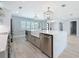 Spacious kitchen with waterfall island, farmhouse sink, stainless steel appliances, and modern pendant lighting at 240 N Julia Cir, St Pete Beach, FL 33706
