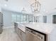 Large kitchen island with stainless dishwasher, sink, and pendant lighting in an open layout at 240 N Julia Cir, St Pete Beach, FL 33706