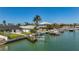 Beautiful waterfront home with lush green lawn and dock provides convenient access for boating and waterfront living at 240 N Julia Cir, St Pete Beach, FL 33706