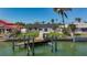 Gorgeous waterfront view of the home featuring a private dock with boat lift, providing direct access to the water at 240 N Julia Cir, St Pete Beach, FL 33706