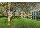 Peaceful lakefront view with green grass and mature trees at 5969 Terrace Park N Dr # 304, St Petersburg, FL 33709