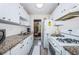 Well-equipped kitchen with granite countertops and white cabinets at 5969 Terrace Park N Dr # 304, St Petersburg, FL 33709