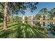 Beautiful lakefront property with tall pines and lush grass at 5969 Terrace Park N Dr # 304, St Petersburg, FL 33709