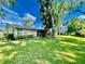 Single story house with green lawn and mature trees at 1223 Queen Anne Dr # C, Palm Harbor, FL 34684