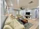 Living room with light beige leather sofas, a coffee table, and a large TV at 1223 Queen Anne Dr # C, Palm Harbor, FL 34684