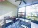 Bright sunroom with wicker furniture and screened windows overlooking a lush garden at 1223 Queen Anne Dr # C, Palm Harbor, FL 34684
