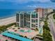 High-rise beachfront condo complex featuring turquoise awnings, a pool, and covered parking near the beach at 1380 Gulf Blvd # 307, Clearwater Beach, FL 33767