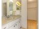 Bathroom featuring a single sink vanity with a mirror and lighting fixture, adjacent to a walk-in closet at 1380 Gulf Blvd # 307, Clearwater Beach, FL 33767