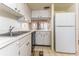 Cozy kitchen with white cabinets and stainless steel sink and refrigerator at 1380 Gulf Blvd # 307, Clearwater Beach, FL 33767