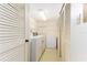 Well-lit laundry room with washer, dryer, freezer, and storage shelving at 1380 Gulf Blvd # 307, Clearwater Beach, FL 33767