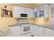 White corner kitchen with granite countertops and ample cabinet space at 6131 Bahia Del Mar Blvd # 236, St Petersburg, FL 33715