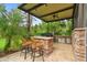 Outdoor kitchen with built-in grill, granite countertops, and seating area at 3204 Polo Pl, Plant City, FL 33566