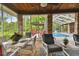 Bright screened porch with dining area and view of the pool and lush landscape at 3204 Polo Pl, Plant City, FL 33566