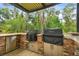 Stainless steel grills and stone countertop in a covered outdoor kitchen at 3204 Polo Pl, Plant City, FL 33566