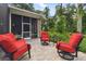 Peaceful patio seating area with red chairs and lush green surroundings at 3204 Polo Pl, Plant City, FL 33566