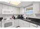 Modern kitchen with white cabinets, granite counters & stainless steel appliances at 4510 Gulf Blvd # 508, St Pete Beach, FL 33706
