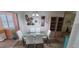 Dining area with glass-top table and white chairs near built-in shelving at 9901 111Th Ln, Seminole, FL 33772