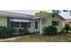 Light-yellow single-story house with green shrubs and a walkway at 9901 111Th Ln, Seminole, FL 33772