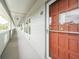 Building hallway with light-grey walls and a red door at 2228 Swedish Dr # 42, Clearwater, FL 33763
