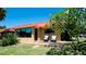 Charming home featuring a red roof, complemented by an outdoor seating area, and verdant landscaping at 4216 La Costa Cv # 4216, Bradenton, FL 34210