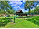 Playground with a wooden play structure, slide, swings, and grassy area at 2707 14Th Ct, Palm Harbor, FL 34684