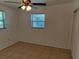 Well-lit bedroom with tile floors and ceiling fan at 6639 Sandra Dr, Port Richey, FL 34668