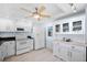 White kitchen with ample cabinetry, microwave, stove, and refrigerator at 138 1St E St # 106, Tierra Verde, FL 33715