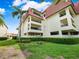 Condo building exterior with lush landscaping and parking at 138 1St E St # 106, Tierra Verde, FL 33715