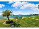 Peaceful waterfront view with palm trees and a park bench at 138 1St E St # 106, Tierra Verde, FL 33715