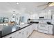 Well-equipped kitchen with white cabinets, modern appliances, and a breakfast bar at 138 1St E St # 106, Tierra Verde, FL 33715