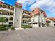Condo building exterior with parking and landscaping at 138 1St E St # 106, Tierra Verde, FL 33715