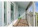 Private screened balcony with wooden flooring and outdoor seating at 9166 Blind Pass Rd, St Pete Beach, FL 33706