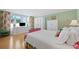 Bedroom with white bedding, green wallpaper and a white dresser with TV at 50 Coe Rd # 331, Belleair, FL 33756