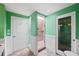 Bathroom with a walk-in shower, green walls, and white wainscoting at 50 Coe Rd # 331, Belleair, FL 33756