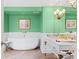 Bathroom with a freestanding tub, green walls, and white wainscoting at 50 Coe Rd # 331, Belleair, FL 33756