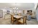Open concept dining area with seating for four, adjacent to kitchen and living room at 36750 Us Highway 19 N # 20-213, Palm Harbor, FL 34684