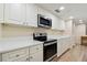 Clean and bright kitchen with white cabinets and stainless steel appliances at 36750 Us Highway 19 N # 20-213, Palm Harbor, FL 34684