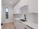 Contemporary laundry room with white cabinets, a black faucet, and a window at 2519 N Riverside Dr, Tampa, FL 33602