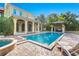 Resort-style backyard oasis featuring a pool, spa, and outdoor kitchen at 7725 Still Lakes Dr, Odessa, FL 33556