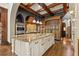 Open kitchen with large island, custom cabinetry, and wood beam ceiling at 7725 Still Lakes Dr, Odessa, FL 33556