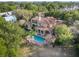 Luxury home with pool, surrounded by lush landscaping, seen from above at 7725 Still Lakes Dr, Odessa, FL 33556