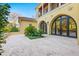 Stunning exterior with arched entryways and a large stone patio at 7725 Still Lakes Dr, Odessa, FL 33556